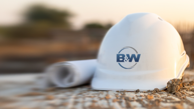 Close up of a hardhat and blueprint roll